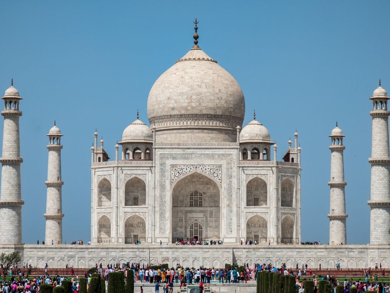 A captivating view of the Taj Mahal under a clear blue sky, showcasing its iconic architecture.