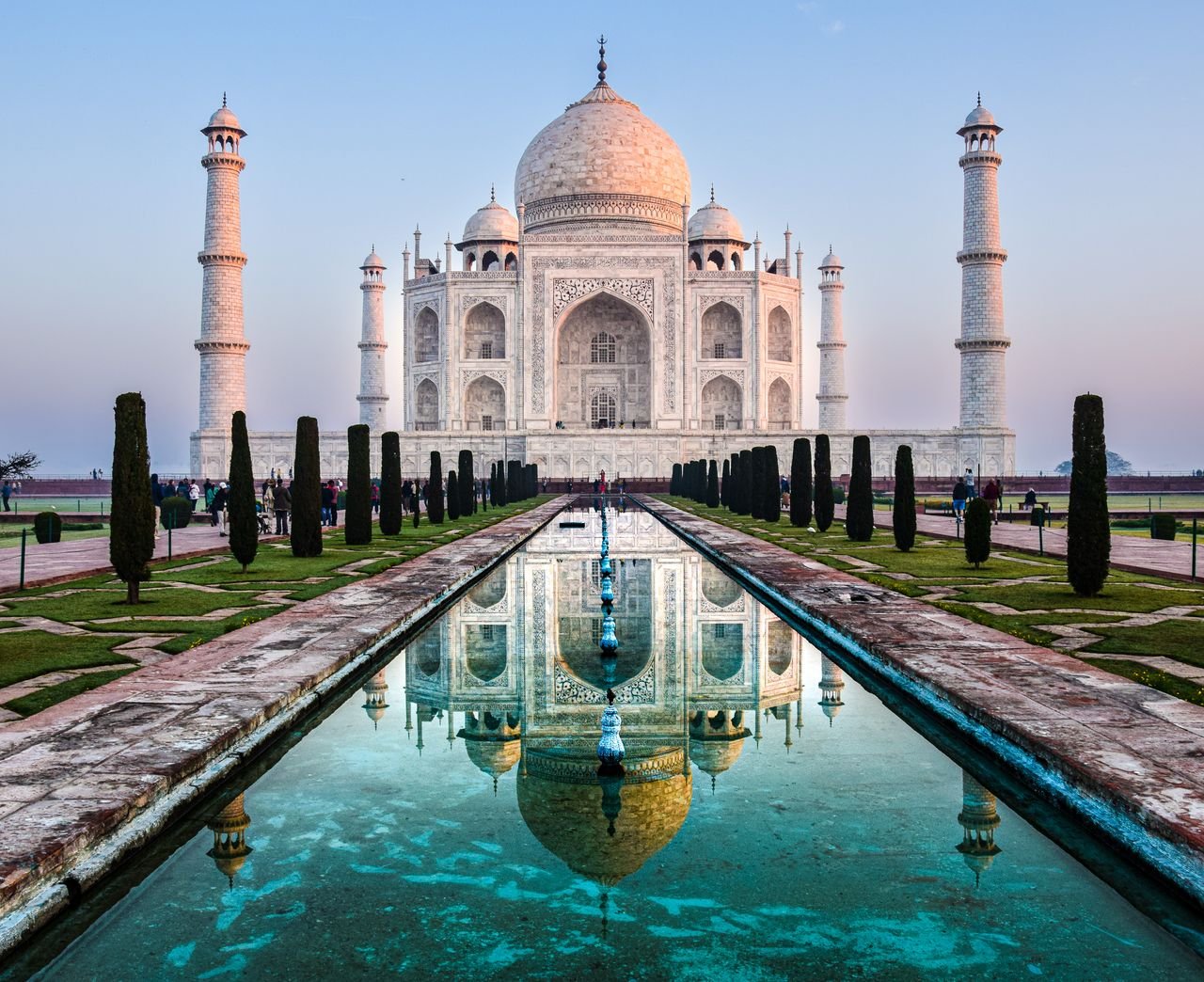 Stunning reflection of the Taj Mahal in Agra, India captured at sunrise.