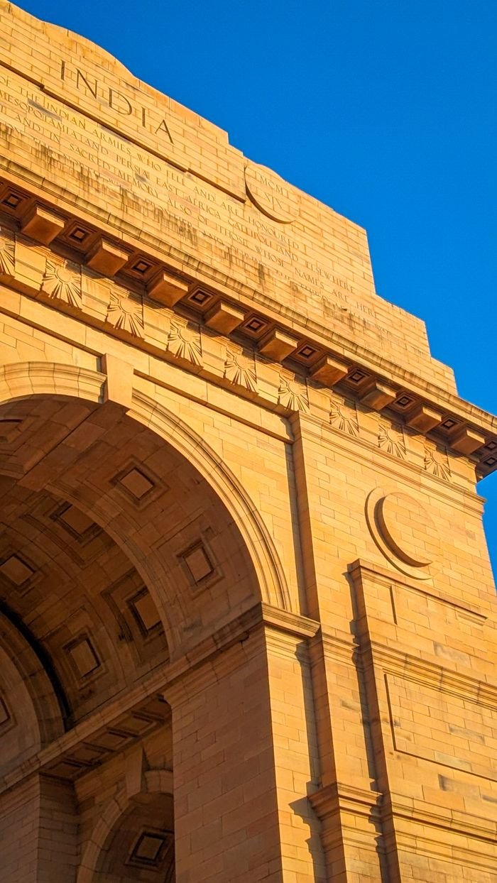 Close-up of the iconic India Gate in New Delhi, highlighting its architectural elegance against a clear blue sky.